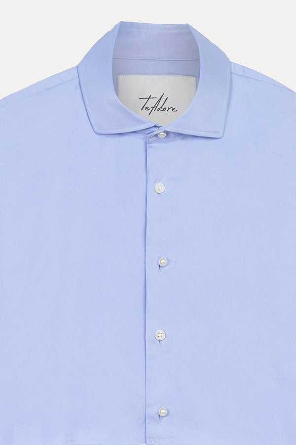 Close-up detail of pearl-accented buttons on luxury designer blue cotton shirt – Tina cropped top